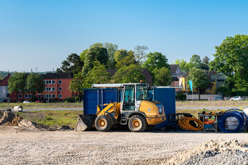 Obraz premium Construction site with a yellow wheeled bulldozer standing on it and folded cables.