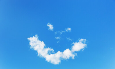 Blue sky and white heart-shaped clouds on clear day. Clouds in the form of smiley face.