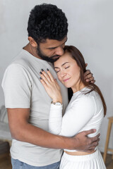Fototapeta premium Multiethnic couple embracing at home.