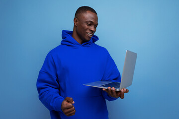 handsome 25 year old american businessman in stylish hoodie with laptop on background with copy...