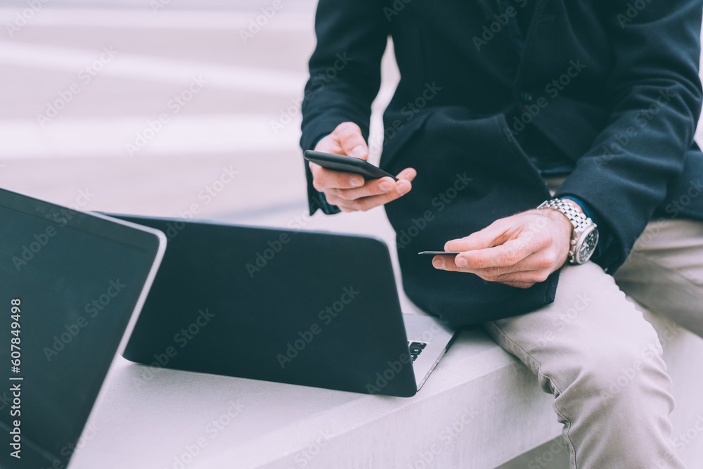 Wall mural two young business men outdoor paying online