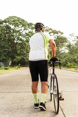 Naklejka premium Unrecognizable senior cyclist man walking with his bicycle.