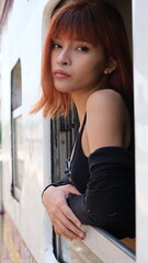 Fototapeta na wymiar Beautiful redhead young woman looks out of the train window