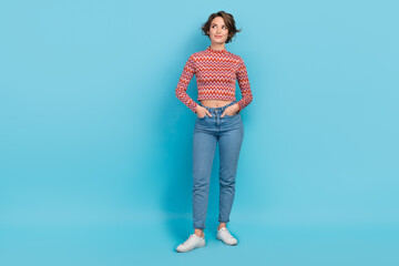 Photo cute lady arms pockets look side empty space interesting news wear shirt denim pants sneakers isolated blue color background