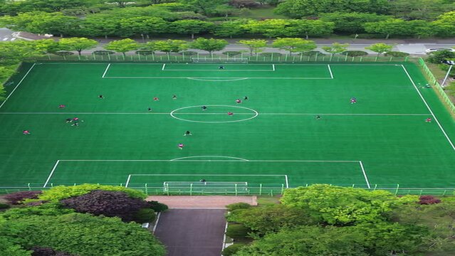 선수들이 분주히 공을 따라 뛰어다니는 대학교 축구경기장