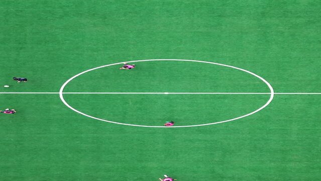 선수들이 분주히 공을 따라 뛰어다니는 대학교 축구경기장