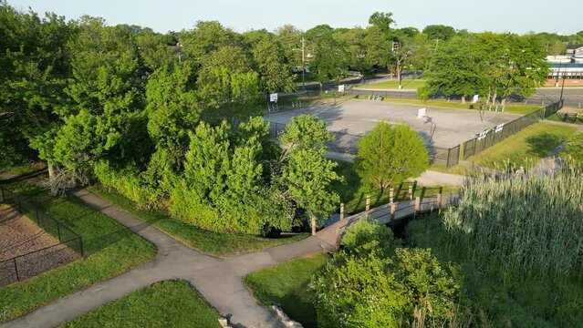 Drone flying over the Park Ave park in Babylon Village looking at a small wooden bridge and ending at the Basketball courts.
