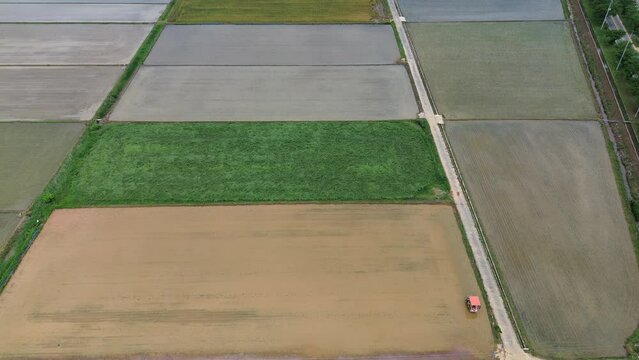 모내기철을 맞이한 바둑판 모양의 논에 물을 대고 흙을 갈아엎는 농기계