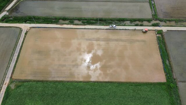 모내기철을 맞이한 바둑판 모양의 논에 물을 대고 흙을 갈아엎는 농기계