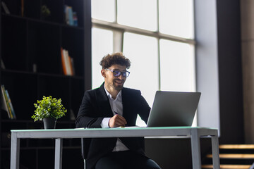 Businessman working in office. Young handsome man working on laptop.