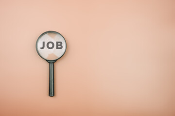 Top view of magnifying glass with job lettering inside. Job search concept. Searching for a hiring