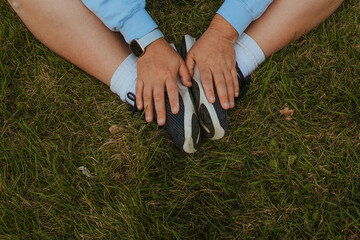 closeup of plus size hands on shoes against grass