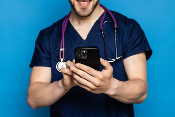 Male on-line doctor man use mobile phone isolated on blue background.