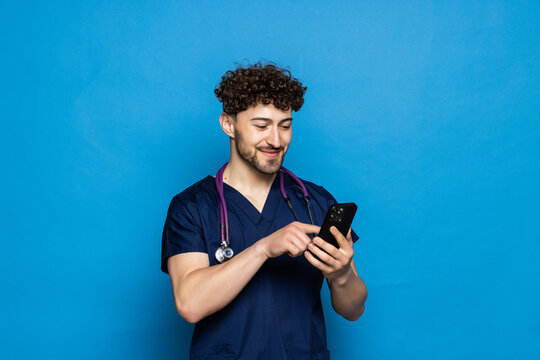 Male on-line doctor man use mobile phone isolated on blue background.