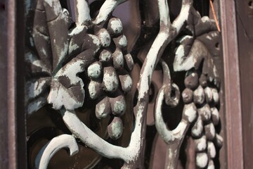 Grape and fruit detail of a metal gate.