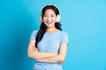 Portrait of a happy smiling asian girl posing on a blue background