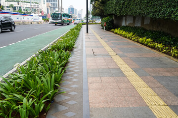 Jakarta, November 9, 2022. Pedestrian sidewalks with beautiful green decorative plants on one of the streets in Jakarta, Indonesia