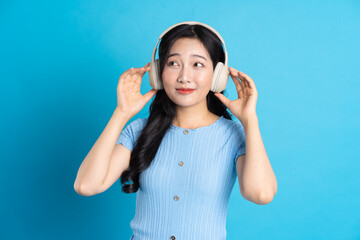 Portrait of a happy smiling asian girl posing on a blue background