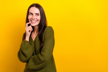 Photo of cheerful nice girl finger touch chin beaming smile look empty space isolated on yellow...