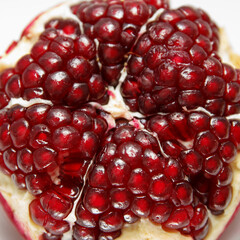 Sweet, ripe peeled red pomegranate. Sections and grains of a large tasty grenade on a white background