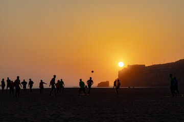 People playing soccer with a view o the sunset in Nazaré Beach