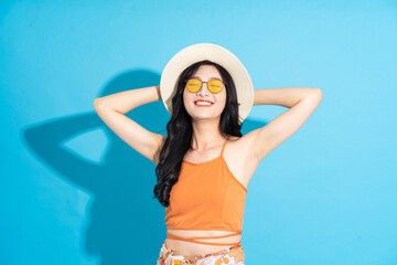 Portrait of a beautiful asian girl in a swimsuit smiling happily on a blue background