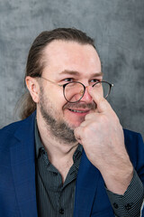 Fototapeta premium One man in a blue jacket adjusts his glasses