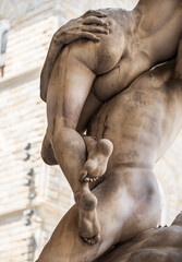 Fototapeta na wymiar Abduction of a Sabine Woman or The Rape of the Sabine Women - a fragment of a real three-figured masterpiece by Giambologna - woman's buttocks hitten man's palms. Old Florence, Tuscany, Italy.