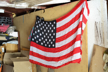 an american flag hangs on a red wooden wall