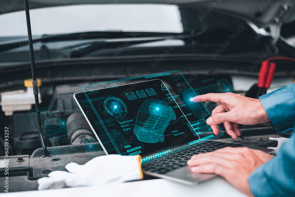 Poster mechanic working close to an automobile engine while using a laptop. a screen-based automotive diagn