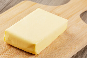 Block of Organtic butter islated on a wooden chopping board