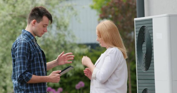 A young engineer advises a client in setting up a heat pump