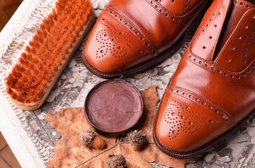 Fototapeta na wymiar Brown leather shoes on table with polishing equipment