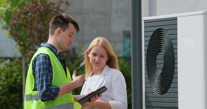 The specialist explains to the customer the principle of operation of the heat pump