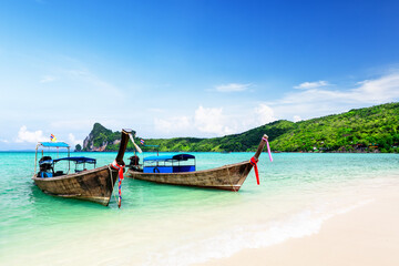 Thai traditional wooden longtail boat and beautiful sand beach at Koh Phi Phi island in Thailand.