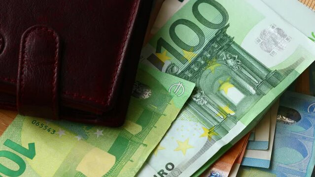 Euro, European Union money, a stuffed Wallet and a large amount of banknotes of different value lying on the table