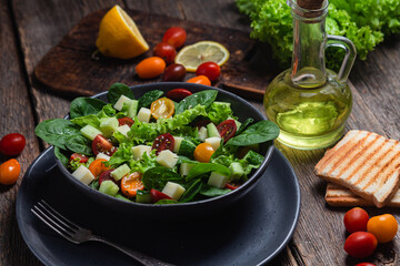 Salad of spinach, cherry tomatoes and cheese in a plate