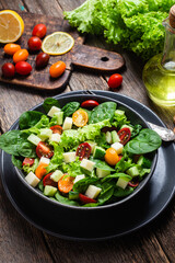 Salad of spinach, cherry tomatoes and cheese in a plate