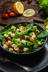 Salad of spinach, cherry tomatoes and cheese in a plate