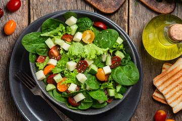 Salad of spinach, cherry tomatoes and cheese in a plate