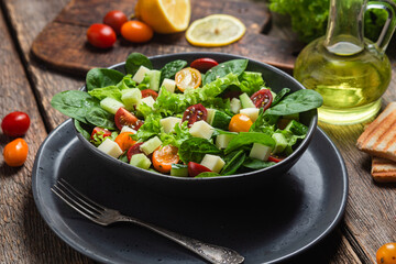 Salad of spinach, cherry tomatoes and cheese in a plate