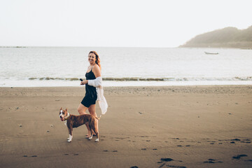 woman running with dog on the beach