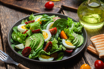 Salad with spinach, avocado, tomatoes in a plate. Vegetarian salad