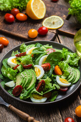 Salad with spinach, avocado, tomatoes in a plate. Vegetarian salad