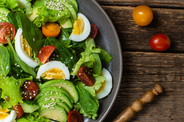 Salad with spinach, avocado, tomatoes in a plate. Vegetarian salad
