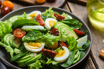 Salad with spinach, avocado, tomatoes in a plate. Vegetarian salad