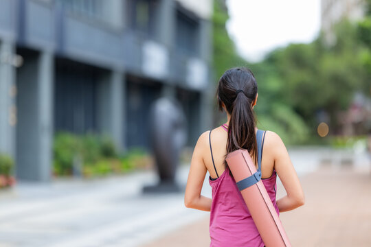 Woman with sport wear and carry her yoga mat