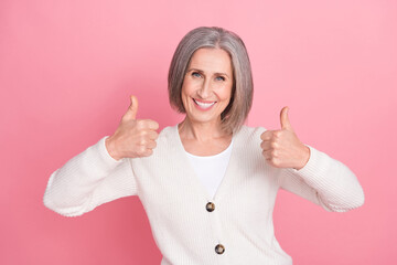 Photo of positive lady toothy smile hands fingers demonstrate thumb up approval isolated on pink...