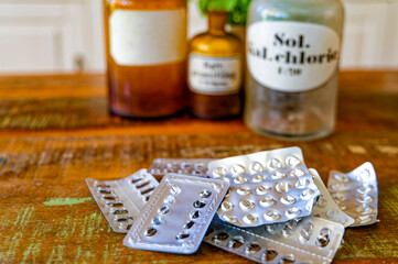 Empty packages of tablets against a blurred background with bottles for chemicals.