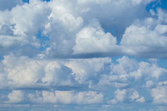 Blue sky with white puffy fluffy clouds, horizontal natural background